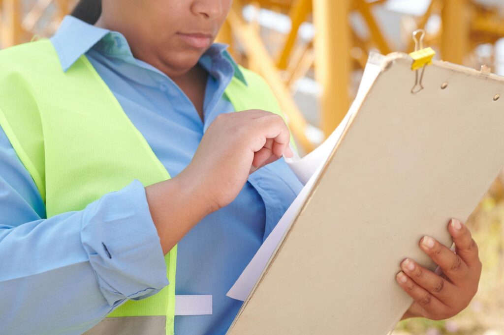 electrical certification documents and inspection on a desk with blueprint background