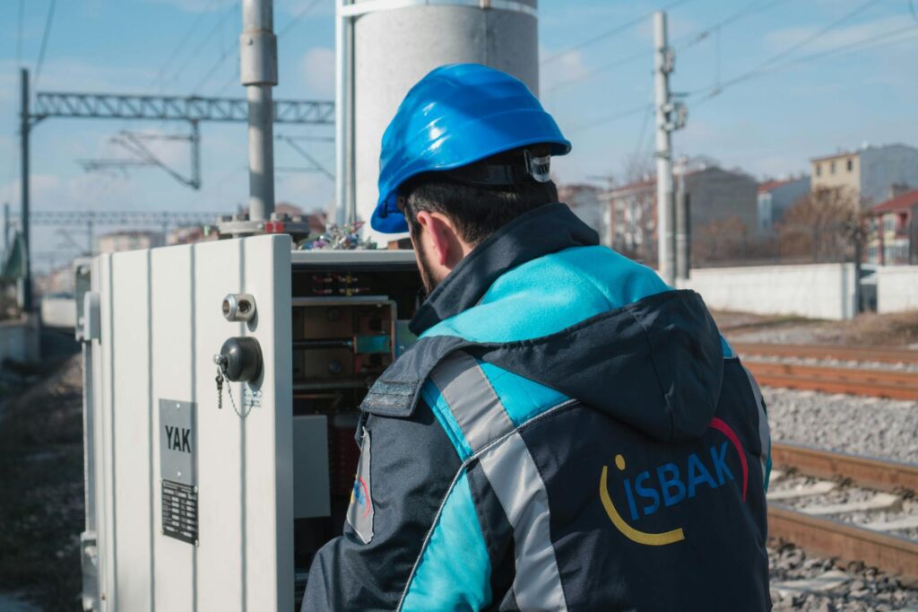 electrician reviewing certification documents and inspecting a circuit breaker panel
