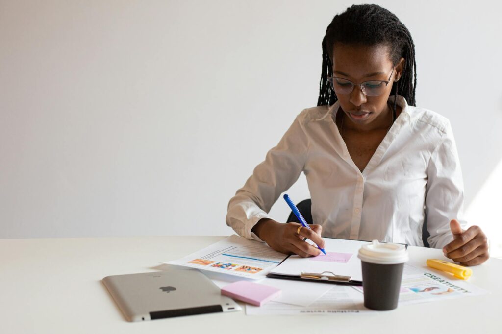 electrician reviewing certification documents and inspecting electrical panel on a work desk