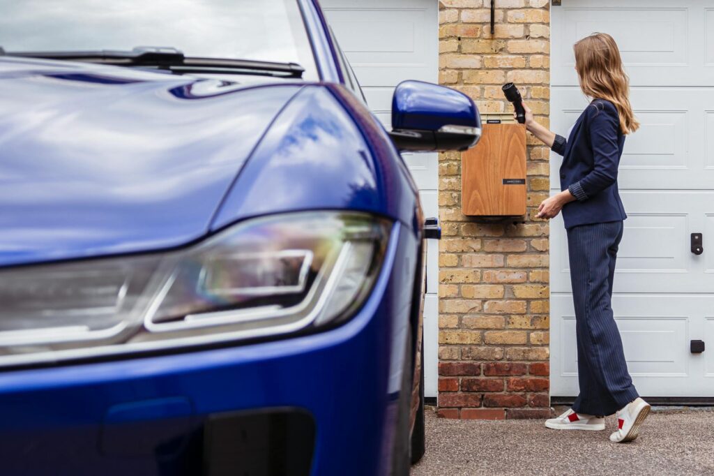 certified electrician installing electric car charger cable in garage