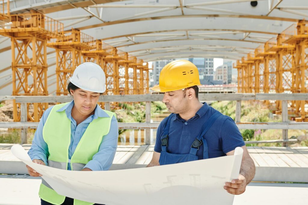 electrical inspection documents and blueprint on desk with safety gear background