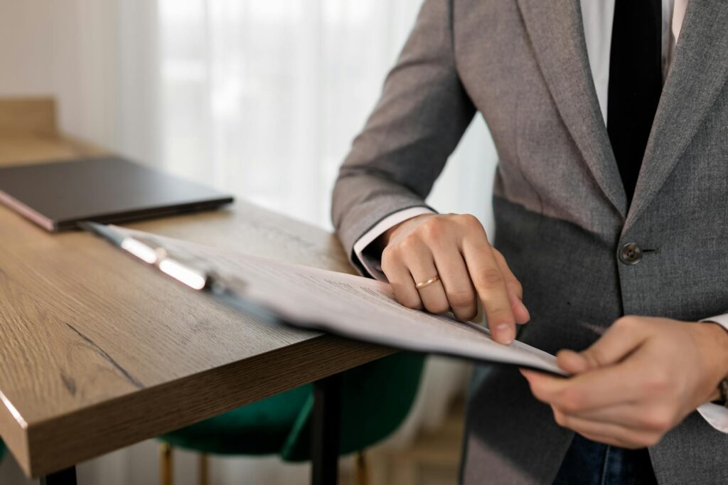 electrician reviewing certification documents and electrical panel plans on a desk