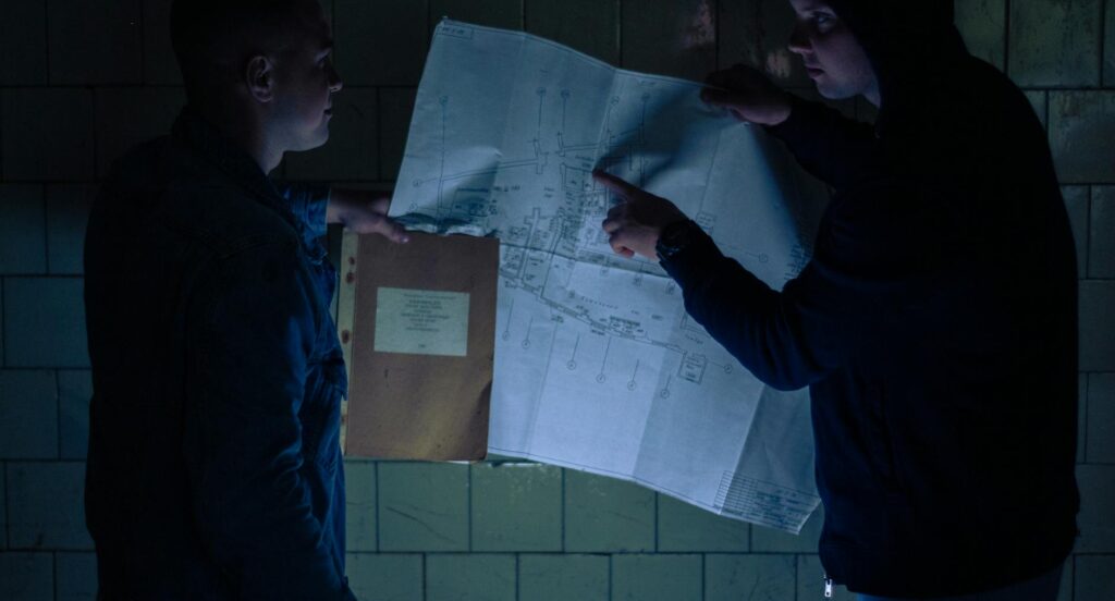 electrician reviewing electrical certification documents on desk with blueprint background