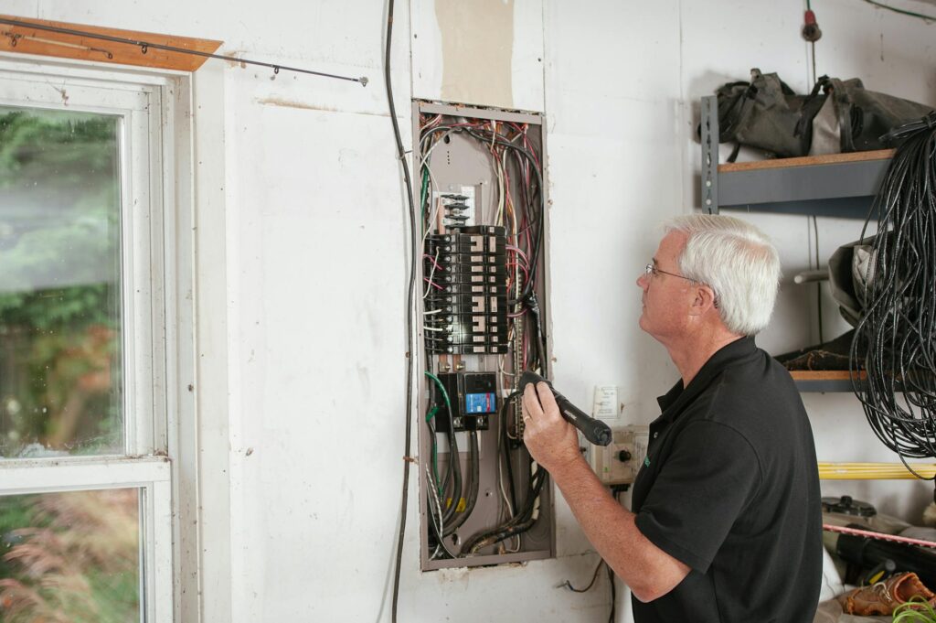 Indonesian electrician inspecting electrical panel with clipboard and official documents