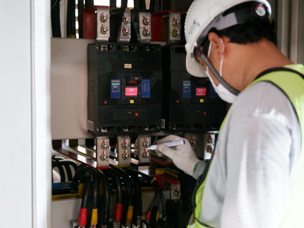 technician checking electrical panel with safety certificate on clipboard
