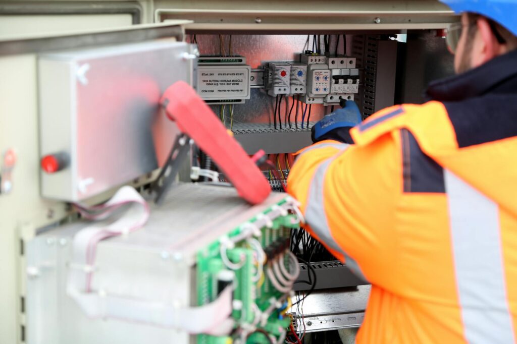 electrician inspecting electrical panel with certificate documents